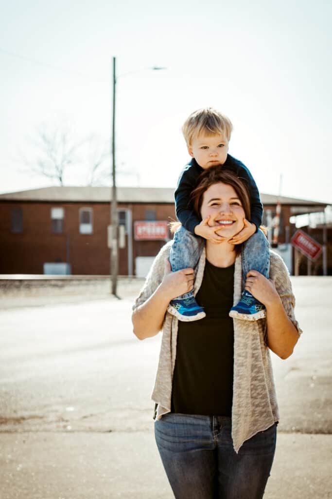 Mom and son in Downtown Madison Alabama in a photography photoshoot. with Andrea Angles Madison AL Photographer. Boy is sitting on moms shoulders