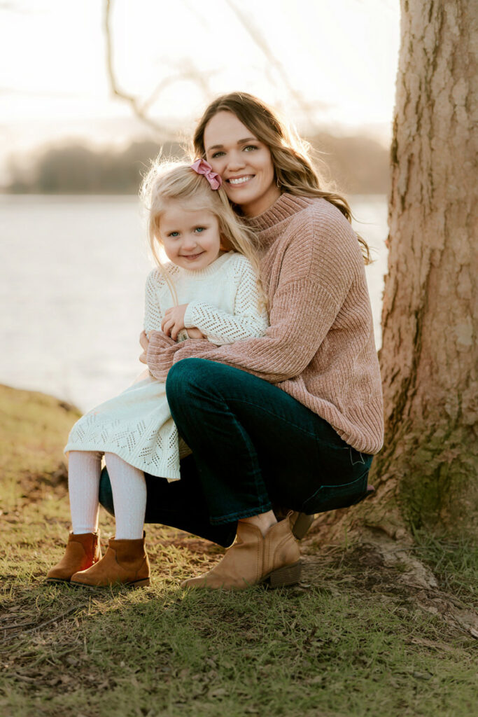 Mom holding her daughter wearing a white dress while posing for a photoshoot in Huntsville Alabama for Andrea Angles Photography